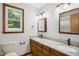 Bathroom with double sink vanity, granite countertops, wood cabinets and framed mirror at 8509 Ashwood Dr, Raleigh, NC 27603