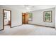 Bright bedroom with neutral carpet, ceiling fan, two windows, walk-in closet, and access to a bathroom at 8509 Ashwood Dr, Raleigh, NC 27603