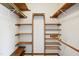 Walk-in closet equipped with custom wood shelving and metal rods for easy storage and organization at 8509 Ashwood Dr, Raleigh, NC 27603