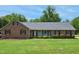 Charming brick home featuring a well-manicured lawn and lovely landscaping at 8509 Ashwood Dr, Raleigh, NC 27603