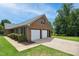Two-car garage with fresh white doors and charming landscaped surroundings at 8509 Ashwood Dr, Raleigh, NC 27603
