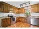 Well-lit kitchen boasts wood cabinets, stainless steel appliances, granite countertops and hardwood floors at 8509 Ashwood Dr, Raleigh, NC 27603