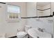 Bathroom with a white tiled wall, toilet, and sink with a mirror at 905 S 1St St, Smithfield, NC 27577