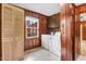 Laundry room with wood-paneled walls, laundry units, and wood cabinets at 905 S 1St St, Smithfield, NC 27577