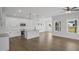 Bright open kitchen featuring white cabinetry, an island with pendant lighting, stainless steel appliances, and hardwood flooring at 91 Merle Way Way, Wendell, NC 27591