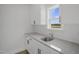 Modern wet bar featuring white cabinets, granite countertops, stainless steel faucet, and a window with a view at 91 Merle Way Way, Wendell, NC 27591