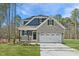 Charming two-story home featuring stone accents, a covered porch, and a two-car garage at Lot 4 Magnolia Acres Ln, Fuquay Varina, NC 27526