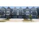 Row of modern townhomes feature neutral exteriors, garages, and professional landscaping at 1004 Regalia Rd # 3, Durham, NC 27713
