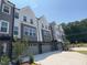 Modern townhouse exterior with gray and white siding and attached garages on a sunny day at 1006 Regalia Rd # 4, Durham, NC 27713