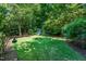 Spacious backyard featuring a lush lawn and mature trees, creating a private outdoor space at 1008 Mockingbird Dr, Raleigh, NC 27615