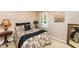 Cozy bedroom featuring a floral bedspread, neutral walls, and natural light from a window at 1008 Mockingbird Dr, Raleigh, NC 27615