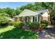 Charming home with lush lawn, brick exterior, mature trees, and inviting front porch at 1008 Mockingbird Dr, Raleigh, NC 27615
