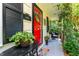 Charming front porch with cozy seating area, bright red door, and verdant potted plants at 1008 Mockingbird Dr, Raleigh, NC 27615