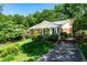 Beautiful brick home featuring a well-manicured lawn and driveway, complemented by mature trees and shrubbery at 1008 Mockingbird Dr, Raleigh, NC 27615