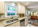 Bright kitchen showcasing granite countertops, stainless steel sink, and off-white cabinetry at 1008 Mockingbird Dr, Raleigh, NC 27615