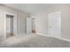 Bedroom with neutral walls, light gray carpet, and several doors at 1029 Whitehall Cir, Durham, NC 27713