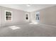 Bedroom with neutral paint, multiple bright windows, and gray carpet at 1029 Whitehall Cir, Durham, NC 27713