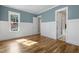 Bright bedroom with hardwood floors, wainscoting, blue walls, and natural light from the window at 1029 Whitehall Cir, Durham, NC 27713