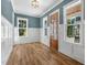 Sun-filled living room showcasing hardwood floors, a decorative chandelier, and beautiful woodwork at 1029 Whitehall Cir, Durham, NC 27713