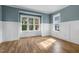 Bright and airy living room with hardwood floors, large windows, and wainscoting at 1029 Whitehall Cir, Durham, NC 27713