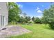 A backyard featuring a stone patio and a yard with many trees that offer shade at 105 Walehurst Ridge Dr, Angier, NC 27501