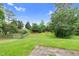 A backyard featuring a green yard, trees, and a wooden fence at 105 Walehurst Ridge Dr, Angier, NC 27501