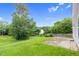 A backyard with a stone patio, a large green lawn, and a tree-lined perimeter at 105 Walehurst Ridge Dr, Angier, NC 27501