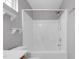 Bright bathroom with a white shower and tub combo, shelves, and a window at 105 Walehurst Ridge Dr, Angier, NC 27501