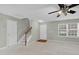 The cozy living room is complete with a ceiling fan, neutral walls and carpet, and a staircase at 105 Walehurst Ridge Dr, Angier, NC 27501