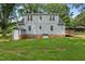 Exterior shot of the home's backyard featuring a manicured lawn, gray siding and wood deck at 1052 Hughes Trl, Elon, NC 27244