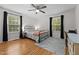 Bright bedroom featuring hardwood floors, large windows, and a comfortable metal frame bed at 1052 Hughes Trl, Elon, NC 27244