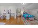 Bright bedroom with wooden floors, white walls, desk, and bed with colorful bedding, creating a playful atmosphere at 1052 Hughes Trl, Elon, NC 27244