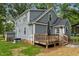 Back of home featuring a wood deck, gray siding, and manicured lawn at 1052 Hughes Trl, Elon, NC 27244