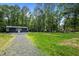 Wide view of a large lot with detached garage and grassy lawn at 1052 Hughes Trl, Elon, NC 27244