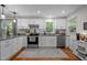 Well-lit kitchen showcases white cabinetry, granite counters, stainless appliances, and hardwood floors at 1052 Hughes Trl, Elon, NC 27244
