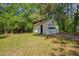 Garage exterior featuring a white door and mature landscaping at 1109 N Pinkston St. St, Henderson, NC 27536