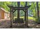 Charming backyard swing with a lattice frame offers a relaxing outdoor retreat, set in a leafy yard at 1115 Chestnut Dr, Smithfield, NC 27577