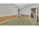 The dining room features wood paneling, a chandelier, green carpet and an open doorway to the kitchen at 1115 Chestnut Dr, Smithfield, NC 27577