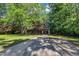 View of the house from the long driveway, surrounded by mature shade trees and well kept lawn at 1115 Chestnut Dr, Smithfield, NC 27577