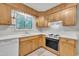 This kitchen features wood-stained cabinets and drawers, a white countertop and a window above the sink at 1115 Chestnut Dr, Smithfield, NC 27577