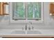 A double basin kitchen sink features a white countertop and a silver faucet with a window view in the background at 1115 Chestnut Dr, Smithfield, NC 27577