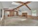 Expansive living room features brick accent wall, fireplace, wood beams, and skylights at 1115 Chestnut Dr, Smithfield, NC 27577