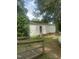 Detached garage with a side entrance, surrounded by mature trees and greenery, blending with the landscape at 112 E Sycamore St, Zebulon, NC 27597