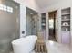 Elegant bathroom featuring a large soaking tub, marble shower, and shelved linen storage at 115 Founders Ridge Dr, Chapel Hill, NC 27517