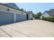 Three-car garage with a concrete driveway and manicured landscaping enhances curb appeal at 115 Founders Ridge Dr, Chapel Hill, NC 27517