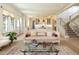 Open-concept living room flowing into the kitchen, featuring elegant decor and a staircase to the upper level at 115 Founders Ridge Dr, Chapel Hill, NC 27517