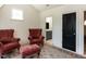 Cozy sitting room with two armchairs, ottoman, and access to a full bathroom at 115 Founders Ridge Dr, Chapel Hill, NC 27517