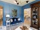 Stylish sitting room with blue accent wall, elegant furniture, and a glimpse into the home's open layout at 115 Founders Ridge Dr, Chapel Hill, NC 27517