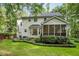 Back exterior featuring a screened porch, bay window, well maintained landscaping, and lush green lawn at 118 Cavendish Ct, Hillsborough, NC 27278