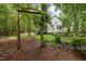 Backyard featuring a charming tree swing, lush greenery, and a serene view of the home at 118 Cavendish Ct, Hillsborough, NC 27278